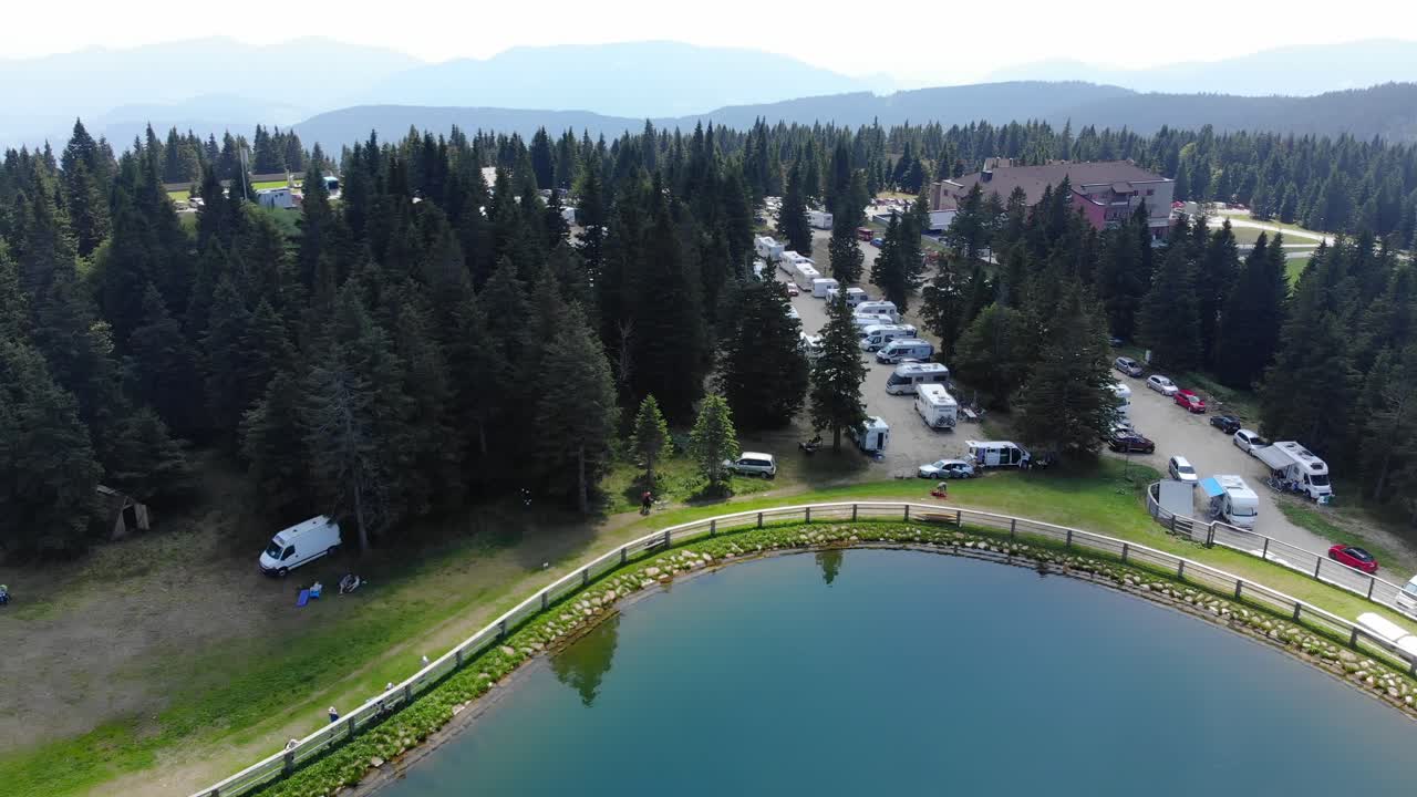 Parco rimorchi nel resort di Rogla, Slovenia, durante la stagione primaverile con un parcheggio affollato, ripresa aerea