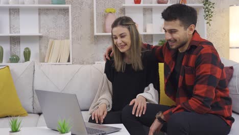 Happy-Young-couple-chatting-with-their-parents-on-video-chat-at-home.