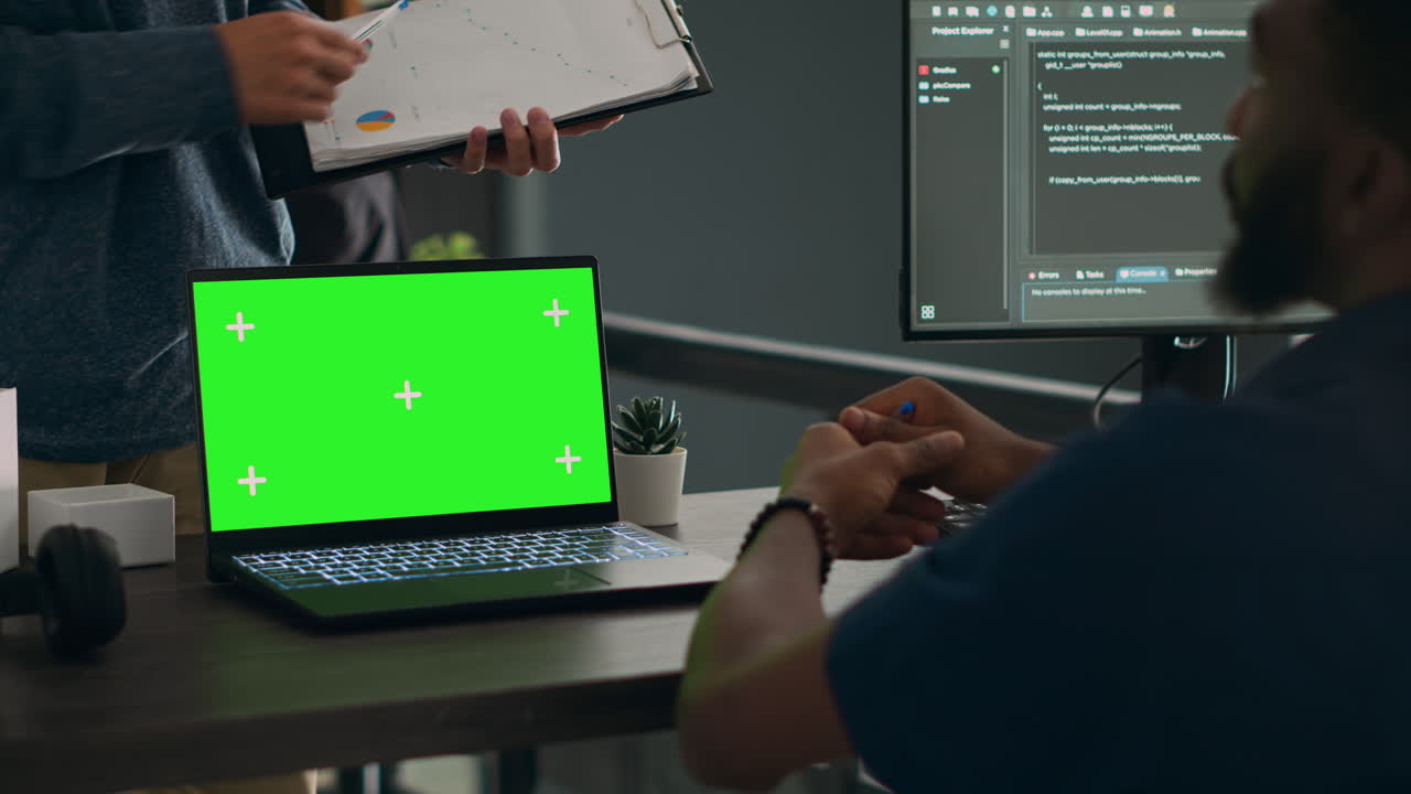 Database admins analyzing source code and greenscreen display on computer