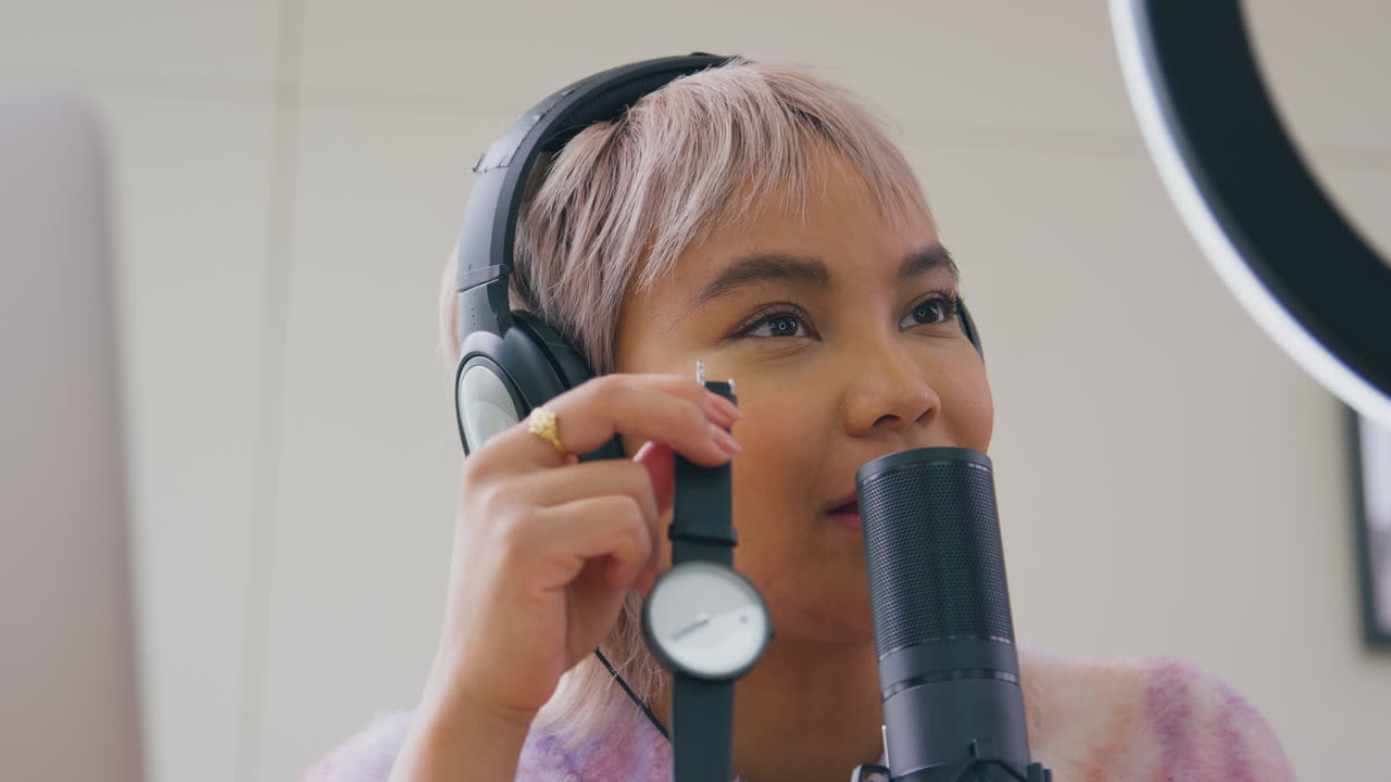 vlogger femenina grabando un video de revisión de producto de reloj de pulsera en casa con una cámara
