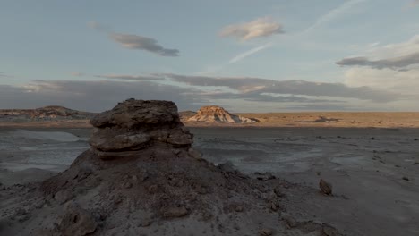 Flight-by-a-desert-butte-to-reveal-another-colorful-formation-illuminated-by-the-sunset