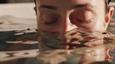 mujer relajándose bajo el agua en una bañera de agua caliente