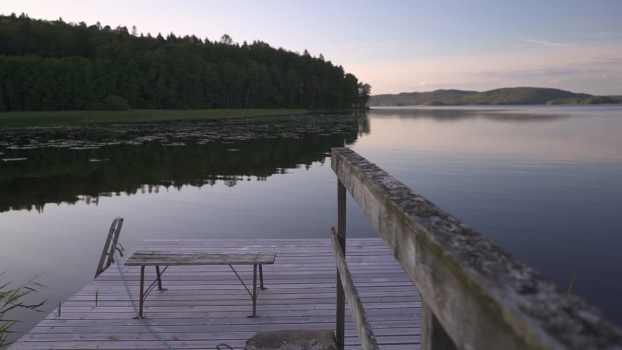 walking out on a jetty looking over a calm lake. summer evening in Sweden.