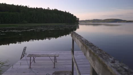 walking out on a jetty looking over a calm lake. summer evening in sweden.