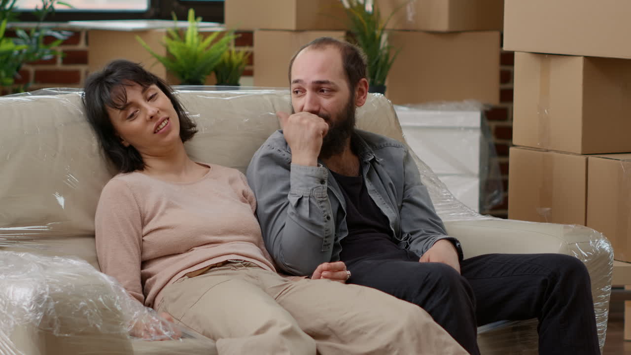 Married couple feeling tired after unpacking furniture and moving in