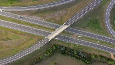 Aerial-drone-of-highway-multilevel-junction-interchange-crossing-road,-spinning-shot