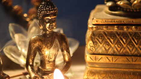 buddha statue with candle burning and incense smoke close up 14