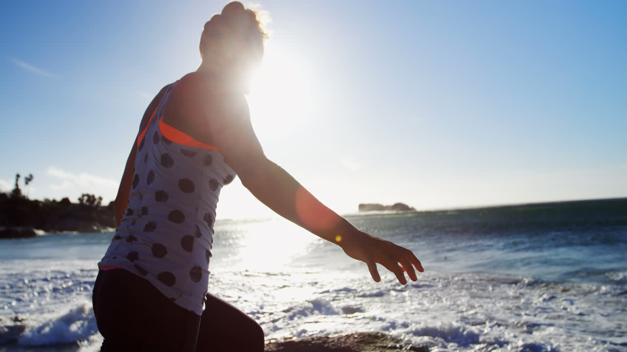 jugadora de voleibol femenina haciendo yoga en la playa 4k