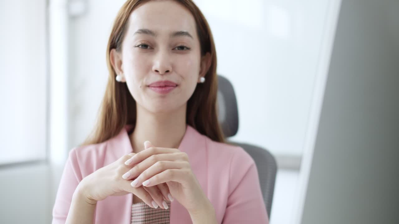 A young woman experiences a moment of joy while working at her desk in a bright digital workspace.