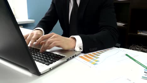 businessman working on laptop with charts and graphs