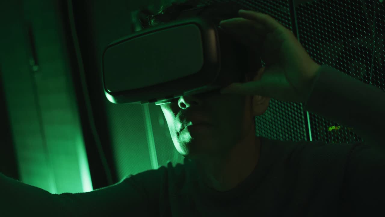 Close up of asian man wearing vr headset by computer servers