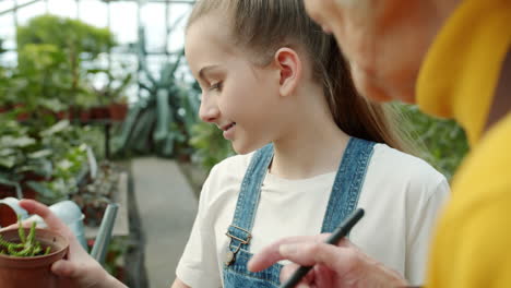 grandmother and granddaughter learning about plants in greenhouse