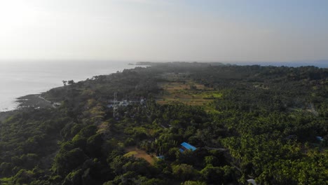 Vista-Panorámica-De-Drones-De-La-Isla-De-Andaman-Al-Atardecer-Con-El-Mar-De-Andaman-En-El-Fondo-Y-Tierras-De-Cultivo-En-Primer-Plano-Con-Pequeñas-Granjas,-Bosques-Y-Campos-Y-Torre-De-Radio-Tv-Internet