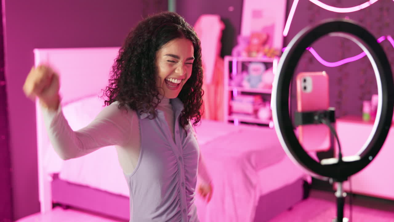 Young woman creating content in her bedroom with ring light