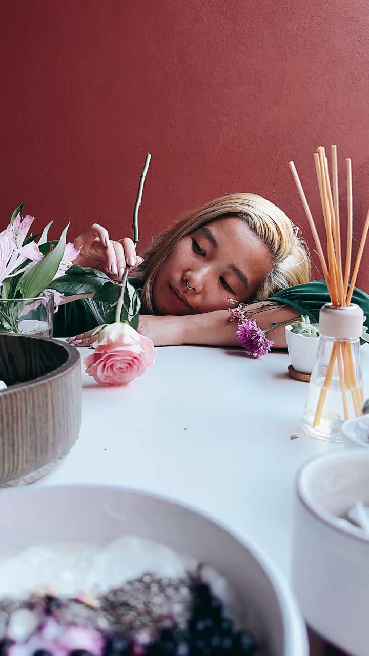 una mujer mirando una rosa.