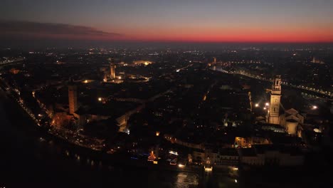 aerial rotating anti-clockwise drone shot, of verona city center at night with sunset