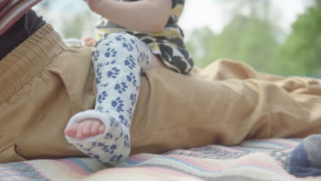 CLOSEUP,-FOCUS-on-PLASTER-of-a-young-childs-broken-leg,-on-mum