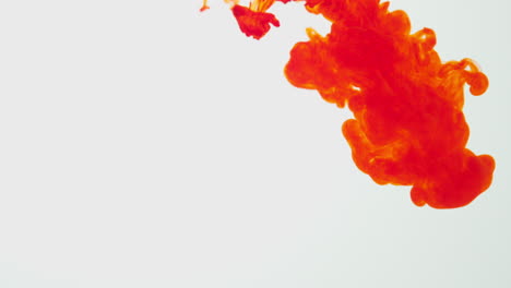 Orange-Paint-Or-Dye-Dropped-Into-Water-Against-White-Background-To-Create-Swirling-Colourful-Smoke-Background-4