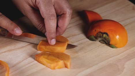 hands slicing persimmon into even pieces