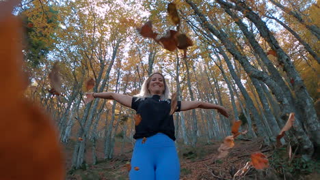 Superslowmotion-Zoom-Aus-Einer-Fitness-Frau,-Die-Herbstblätter-Im-Wald-Fallen-Lässt