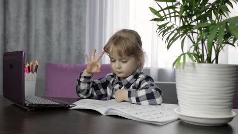 girl studying online homework using digital laptop computer. distance education