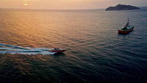 una toma aérea de un avión no tripulado de un barco acelerando en santa marta al atardecer en colombia