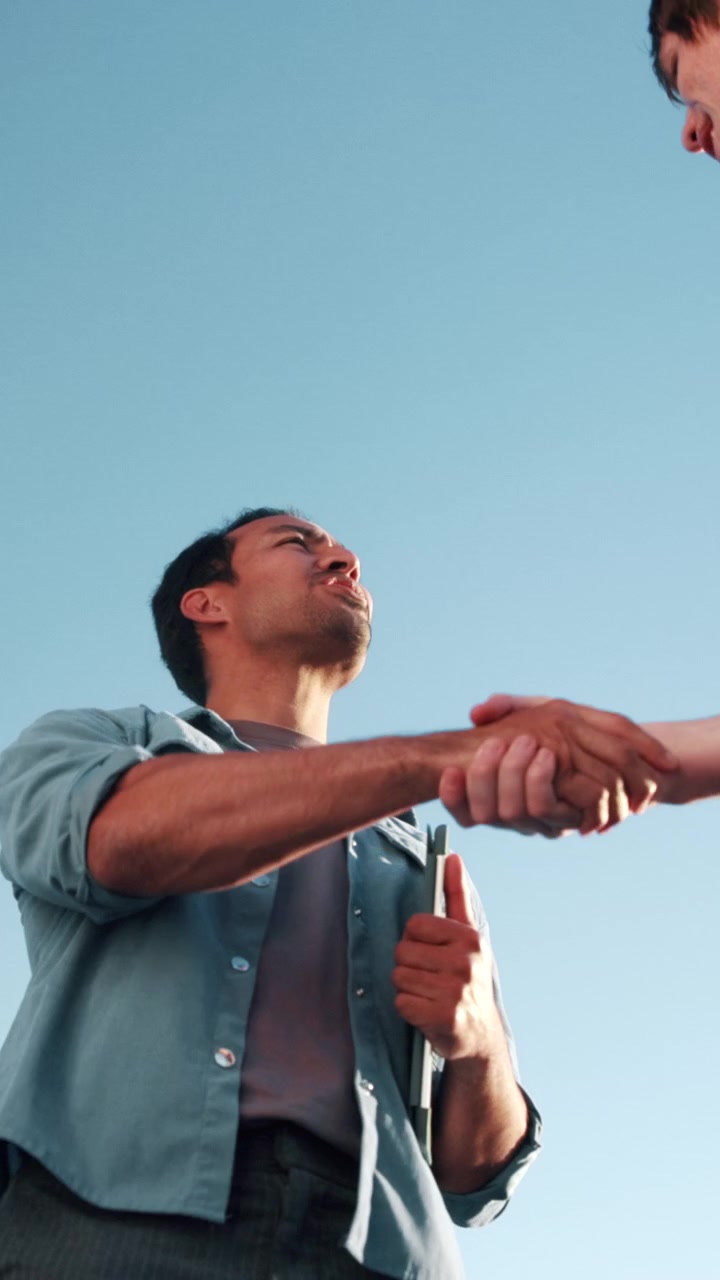 Professional Man Shaking Hands Outdoors Against Clear Blue Sky