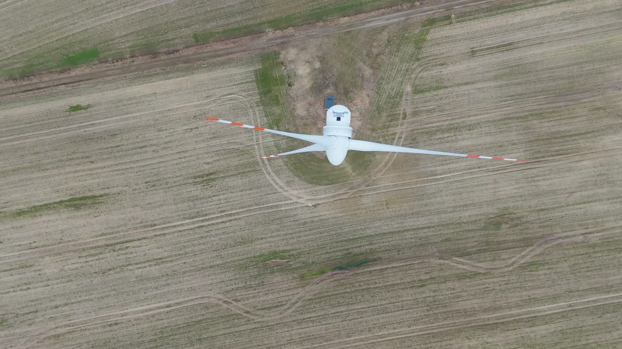 Descending, top-down view of the electricity generating windmill with rotating wings