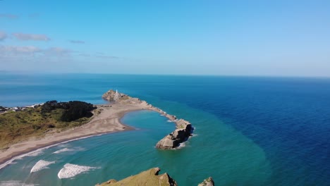 Man-stands-on-a-cliff,-beautiful-scenic-lookout-on-New-Zealand-coast