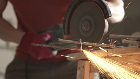 a master builder cuts iron fittings with an angle grinder with a cut-off wheel