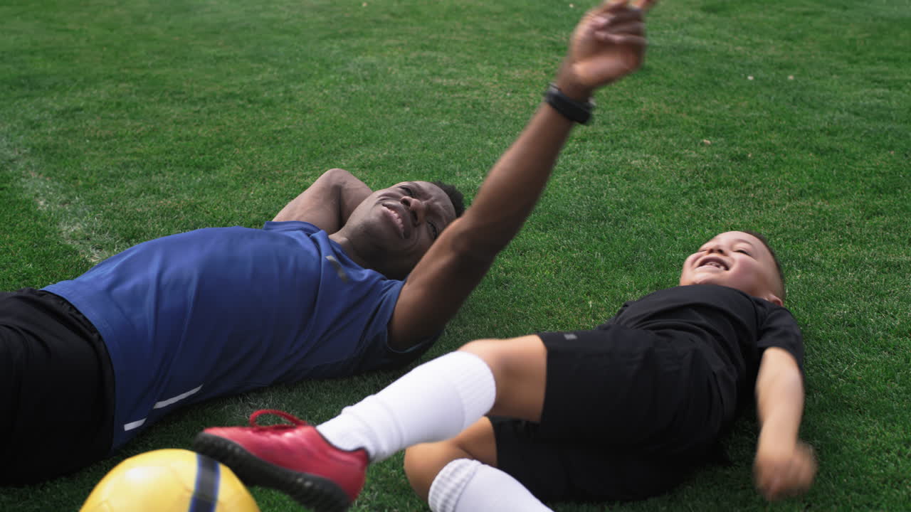 Father and son resting on the soccer field