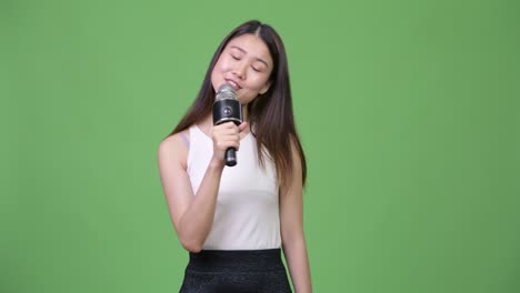 joven y hermosa mujer de negocios asiática cantando