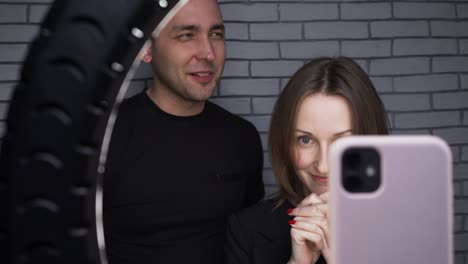 imágenes de una pareja hablando con sus seguidores en el fondo de la pared de ladrillo