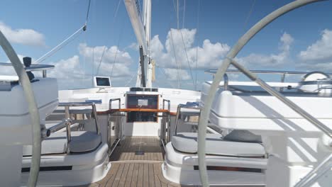 wooden table on deck of oyster 82 luxury sailboat with two helms or steering wheels