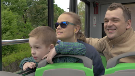 family of three riding in doubledeck bus