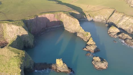 Drohnen-Winternachmittagssonne-An-Einem-Versteckten-Strand-Und-Einer-Geschützten-Bucht-An-Der-Kupferküste-Von-Waterford,-Irland