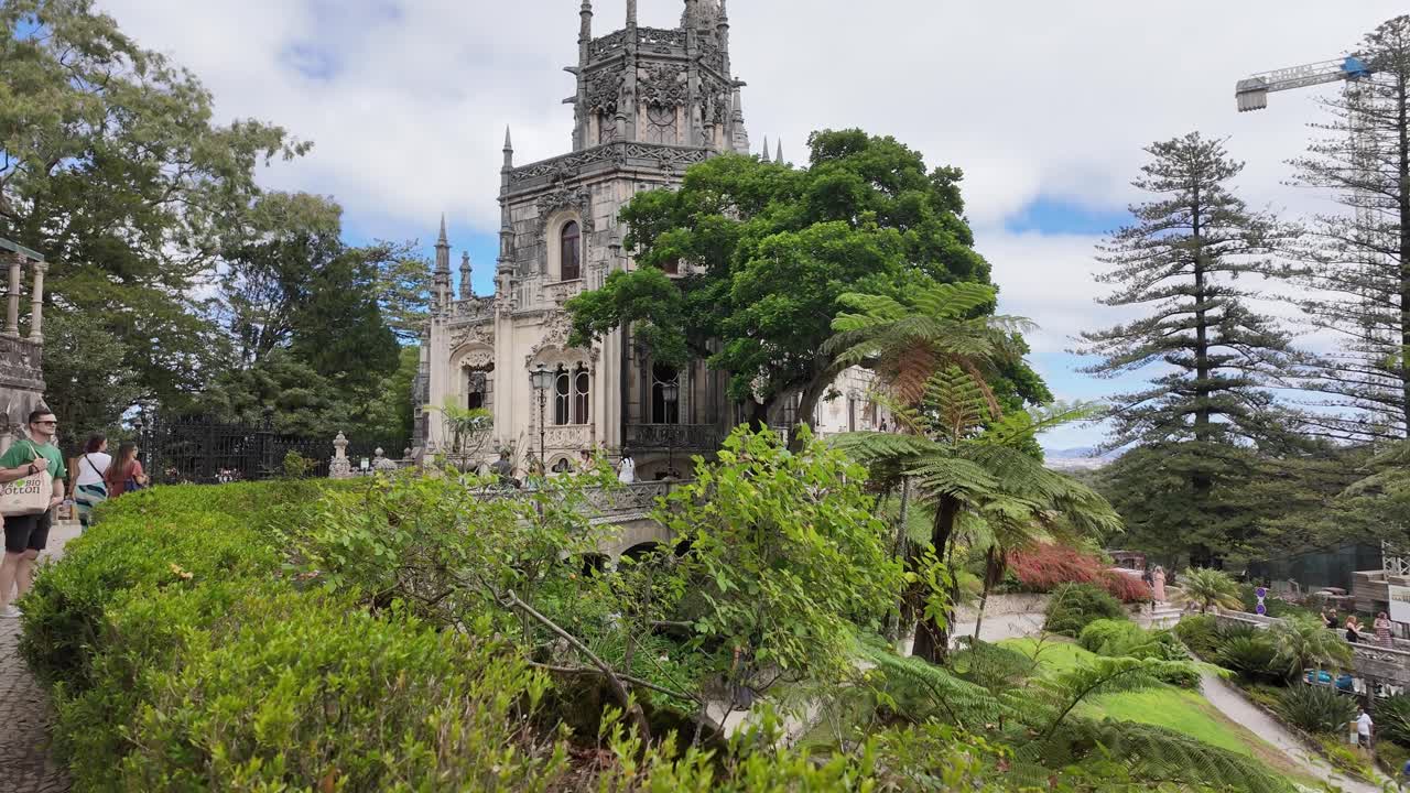 Historic church tower surrounded by trees in Sintra, Portugal under cloudy skies