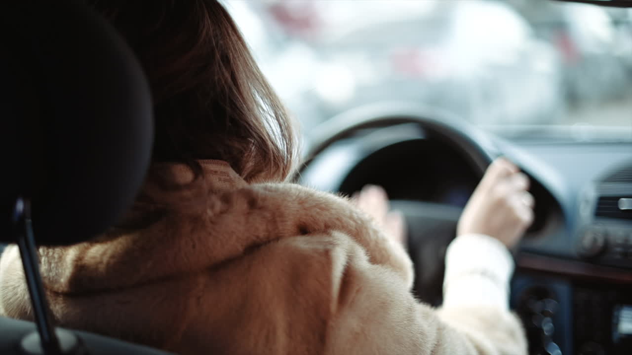 Woman driving a car in slow motion, hands on wheel