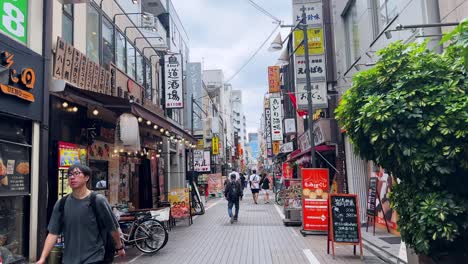 bustling japanese shopping street lined with colorful signs and stores on a cloudy day