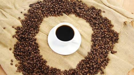 Cup-of-coffee-surrounded-with-roasted-beans