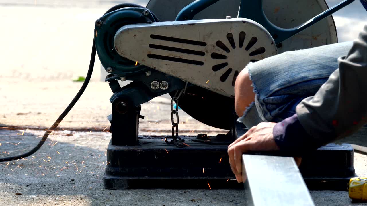 건설 노동자 용접기 손의 4k 클로즈업 은 철강 바를 절단하고 용접에서 불꽃을 만들기 위해 전기 각성 회전기를 사용합니다.