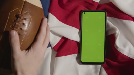 Overhead-Studio-Shot-Of-American-Football-On-Stars-And-Stripes-Flag-With-Green-Screen-Mobile-Phone