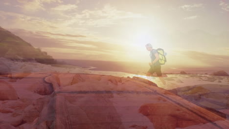 caucasian senior man hiking by the coast over fast moving clouds and sunset