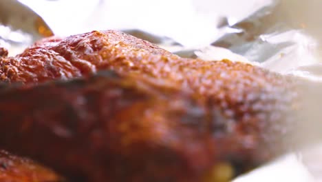 slow moving close up of crispy half duck ready to be eaten after cooking with skin details and leg bone.