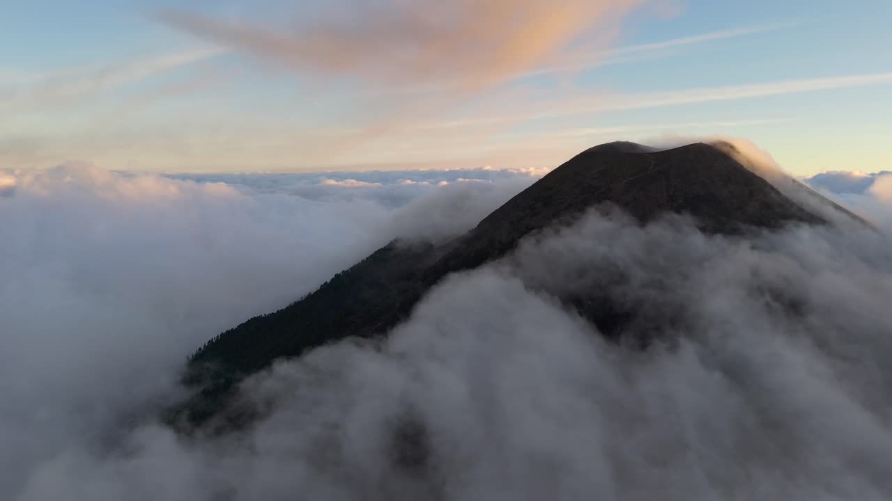 Acatenango Volcano, summit above the clouds at dusk, aerial drone shot