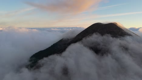 acatenango volcano, summit above the clouds at dusk, aerial drone shot