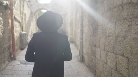 orthodox jewish man walks through jewish quarter, israel