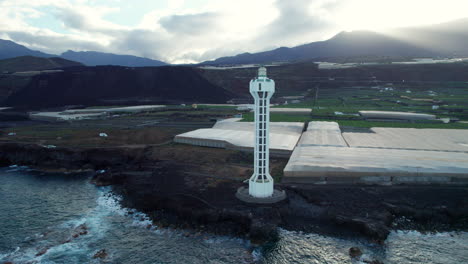 Maravillosa-Vista-Aérea-En-órbita-Sobre-El-Faro-De-Las-Hoyas-Y-Viendo-El-Cinturón-Volcánico-Negro-De-La-Erupción-Del-Volcán-Tajogaite-En-La-Isla-De-La-Palma