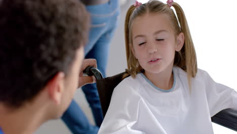 biracial doctor talking to caucasian girl patient sitting in wheelchair in hospital, slow motion