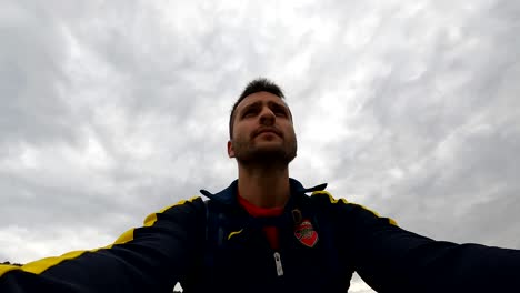 upwards shot of a man's torso as ringing a bike under an overcast sky